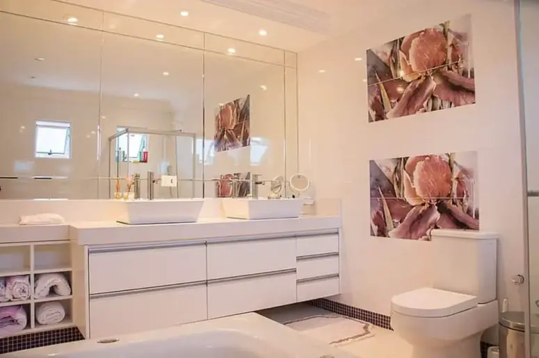 Bathroom with large illuminated mirror.
