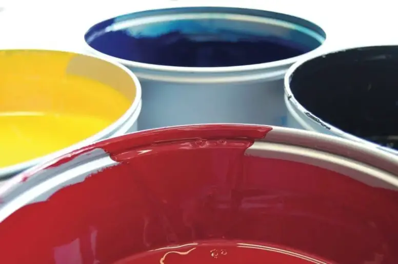 Three buckets of paint in different colors.
