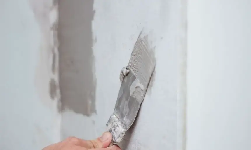 Skim coating a plaster wall.