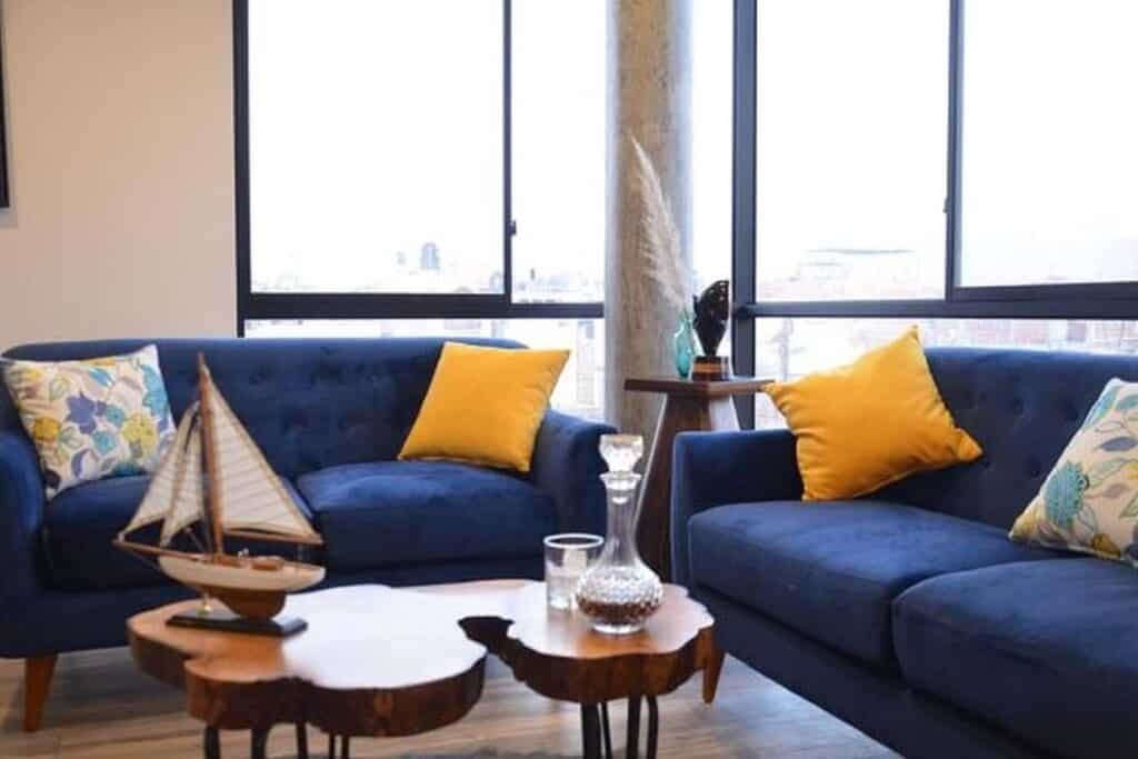 Blue sofas and designer coffe table with maritime deco on it.