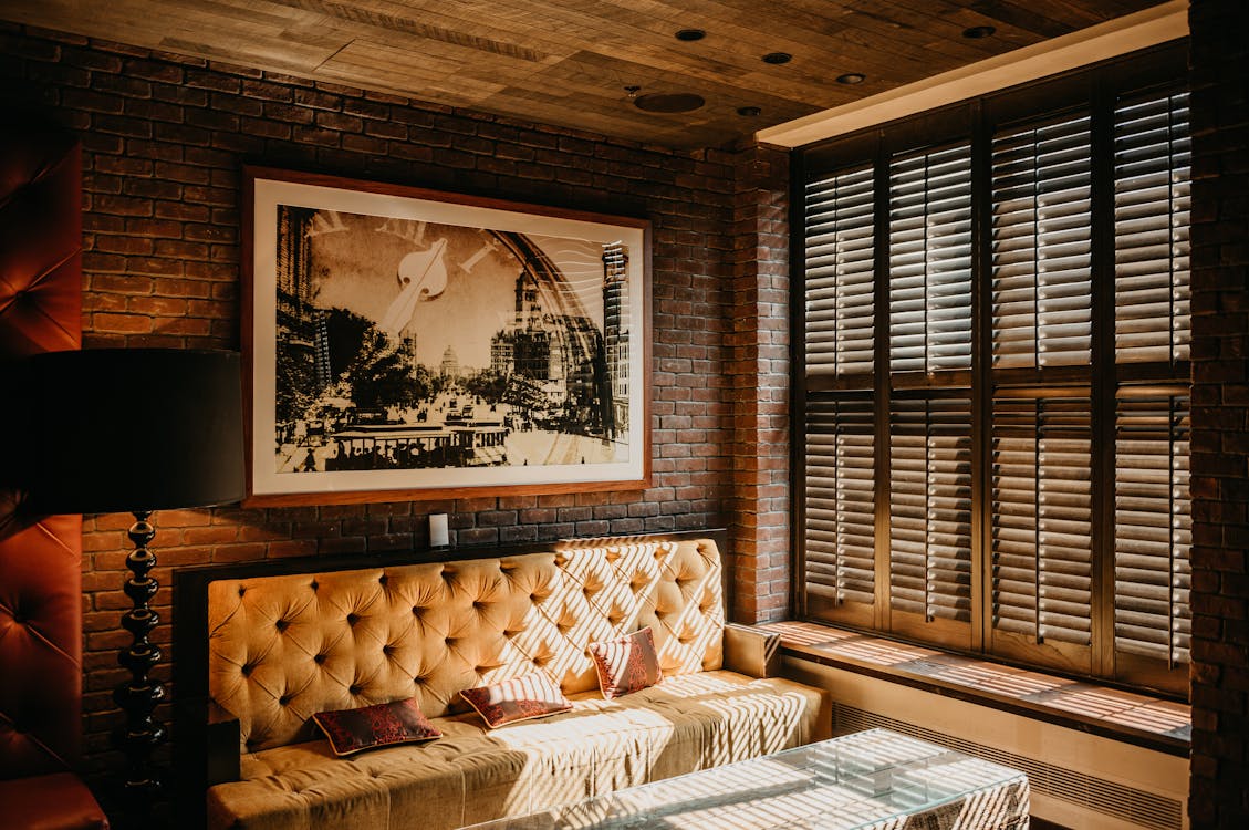 Free Warm and inviting living room featuring modern decor with a brick wall and ample daylight. Stock Photo