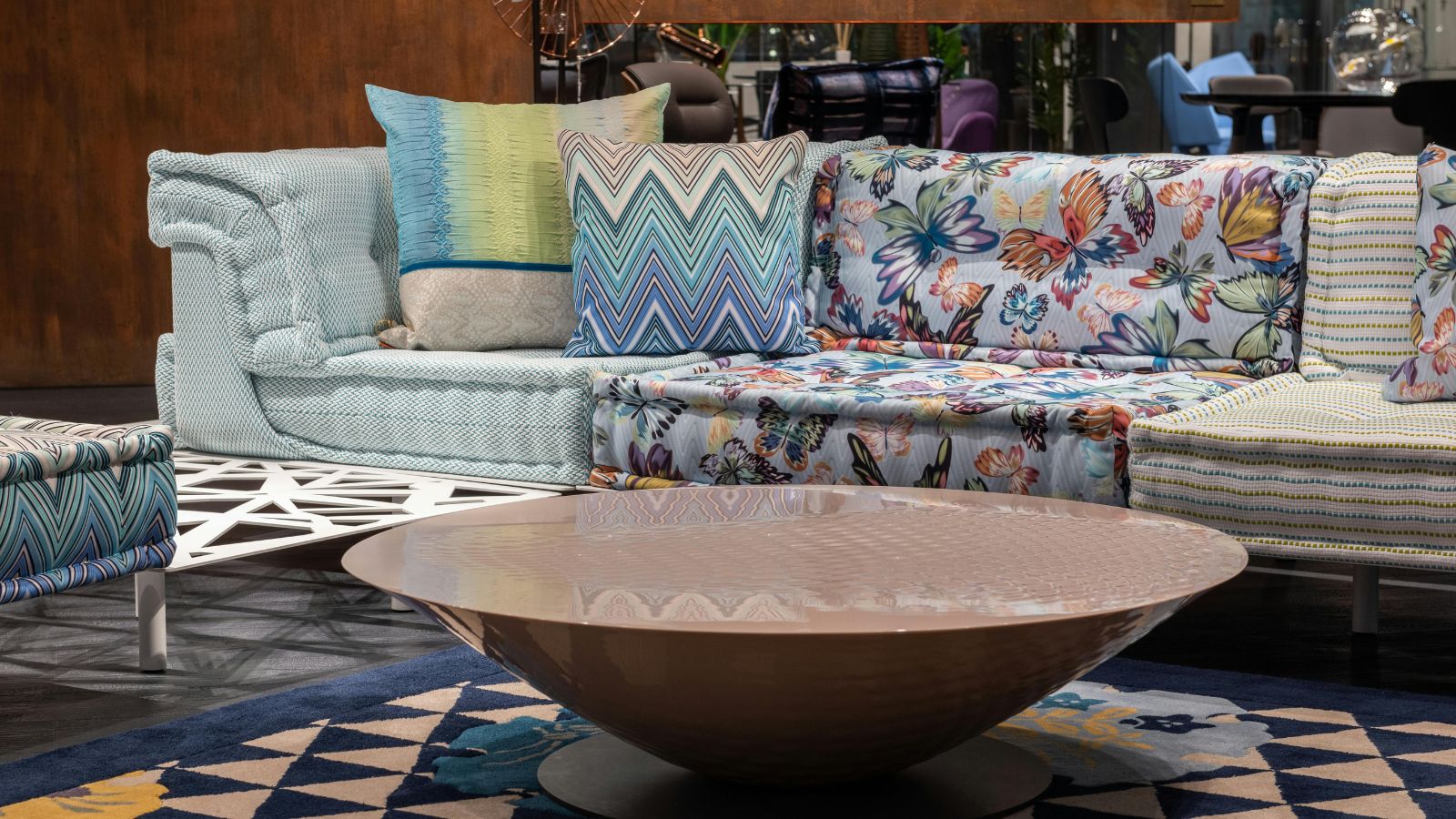 Vibrantly-hued sofa beside a circular coffee table.